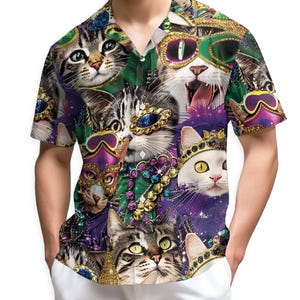 Peut inclure: Chemise à manches courtes avec un collage vibrant de chats portant des masques, des couronnes et des accessoires de Mardi Gras. Le motif de la chemise incorpore des couleurs vertes, violettes, dorées et blanches, créant un motif ludique et accrocheur.