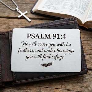 May include: A rectangular silver-toned metal wallet card featuring the engraved text PSALM 91:4, "He will cover you with his feathers, and under his wings you will find refuge." and a small feather icon centered at the bottom of the card.