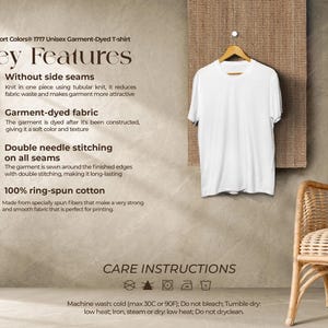 May include: A white Comfort Colors 1777 unisex garment-dyed t-shirt hangs on a wooden hanger. The shirt features key details such as no side seams, garment-dyed fabric, double needle stitching, and 100% ring-spun cotton. Care instructions are also included.