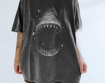 May include: Dark gray oversized t-shirt featuring a detailed graphic of a shark's open mouth with sharp teeth and bubbles. The shirt has a vintage, washed look.