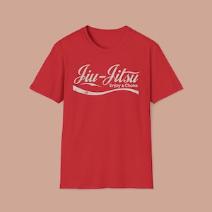 May include: Red t-shirt featuring the words "Jiu-Jitsu" in a white, retro font, with "Enjoy a Choke" below. The shirt is a plain red colour.