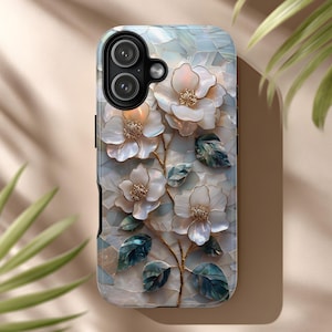 May include: A rectangular smartphone case featuring a mosaic-style design of white, iridescent floral blossoms with gold-toned centers and dark teal leaves. The background consists of a light, pearlescent tiled pattern with a black camera cutout.