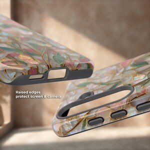 May include: A phone case featuring a pearlescent, multi-colored floral pattern with gold-toned veins and a dark gray interior frame. The case has raised edges to protect the screen and camera, as noted by the text: Raised edges protect screen & camera.