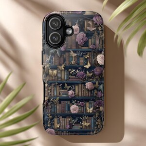 May include: A phone case featuring a detailed illustration of a bookshelf with books, butterflies, and roses in shades of purple, pink, and gold. The case has a glossy finish and a dark blue background.