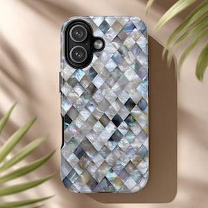 May include: A smartphone case with a mosaic pattern. The case features a repeating diamond pattern in shades of white, gray, and iridescent colors. The camera lenses are visible at the top. The case is designed to protect the phone.