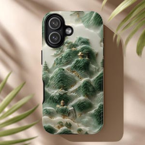 May include: A phone case featuring a 3D landscape design with green mountains, white clouds, and gold accents. The case has a glossy finish and a black border. The design includes a winding path and small buildings.