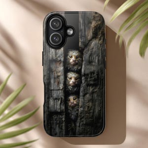May include: Black phone case featuring a detailed image of three small marmoset monkeys peeking through a weathered wooden structure. The monkeys have light brown fur and large, expressive eyes. The case has a glossy finish.
