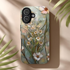 May include: A protective phone case featuring a pearlescent, iridescent background with a printed illustration of delicate white and pale pink wildflowers with green stems and leaves. The case has a black camera cutout for a dual-lens system.