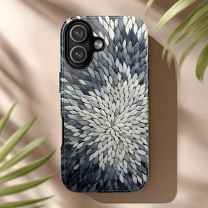 May include: A mobile phone case with a floral pattern. The case displays a design of overlapping, petal-like shapes in shades of grey and white, emanating from the centre. The case has a glossy finish and a black border, with the camera lenses visible.