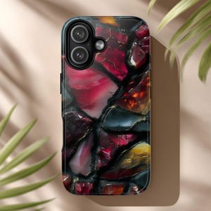 May include: A smartphone case with a stained glass design. The case features a mosaic pattern of red, black, yellow, and gold colors. The case has a glossy finish and a camera cutout.