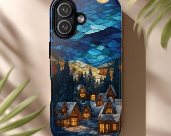 May include: A phone case featuring a stained-glass style winter scene. The design includes a moon, mountains, evergreen trees, and snow-covered houses with lit windows. The color palette is primarily blues, golds, and browns.