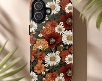 May include: A floral phone case featuring a dark background with a pattern of white daisies, red poppies, and orange and yellow flowers. The case has a glossy finish and a camera cutout.