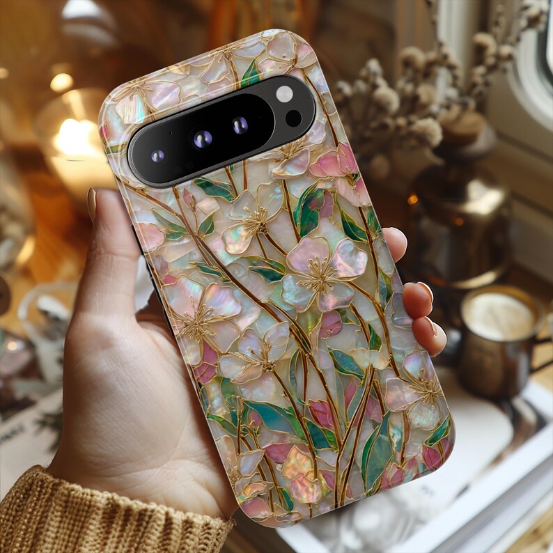 May include: A rectangular smartphone case featuring an iridescent, mother-of-pearl style floral pattern. The design displays pink and white flower petals with green leaves and gold-toned outlines, creating a stained-glass effect across the surface.
