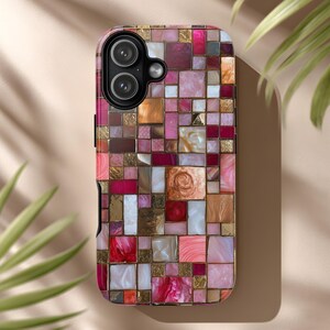 Op de afbeelding: Een telefoonhoesje met een mozaïekontwerp. De hoes heeft een patroon van kleine, onregelmatig gevormde vierkanten in tinten roze, goud en wit. De cameralenzen zijn zichtbaar aan de bovenkant. De hoes heeft een glanzende afwerking.
