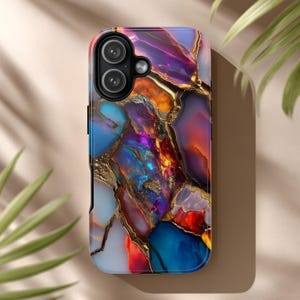 May include: A smartphone case with a colorful abstract design. The case features a pattern of vibrant blues, purples, oranges, and gold, resembling a geode or gemstone. The case has a glossy finish and a camera cutout.