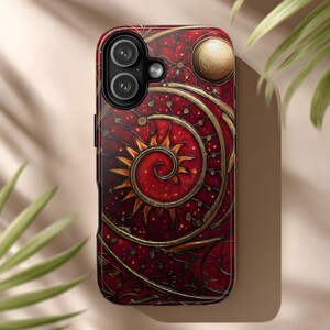 Puede incluir: Una funda de teléfono inteligente con un diseño artístico detallado. La funda presenta un fondo rojo intenso con un patrón de espiral y sol dorado. El diseño incluye pequeños puntos dorados y un elemento circular en la parte superior, creando un aspecto único y decorativo.