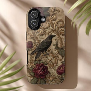 Könnte beinhalten: Handyhülle mit detailliertem Design, das einen dunklen Raben auf einem Ast zeigt, umgeben von burgunderroten Rosen und goldenen Verzierungen auf beigem Hintergrund. Die Hülle hat ein glänzendes Finish.