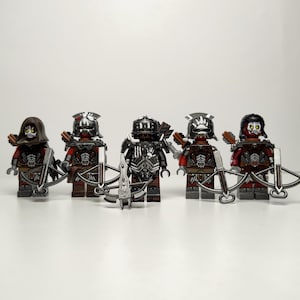 Könnte beinhalten: Fünf Fantasy-Minifiguren in einer Reihe, die jeweils eine dunkelrote und schwarze Rüstung mit silbernen Akzenten tragen. Sie haben skelettartige Gesichter, Helme oder Kapuzen und sind mit silbernen Armbrüsten und Köchern ausgestattet.