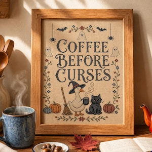 Puede incluir: Un bordado en punto de cruz enmarcado con el texto COFFEE BEFORE CURSES en letras negras. El diseño incluye un ganso blanco con sombrero de bruja, un gato negro, calabazas, fantasmas, murciélagos, arañas y bordes florales sobre tela beige.