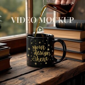 May include: A black coffee mug with gold stars and the text "your design here" is being filled with coffee. The mug sits on a wooden surface next to a stack of books. The words "VIDEO MOCKUP" are in the background.