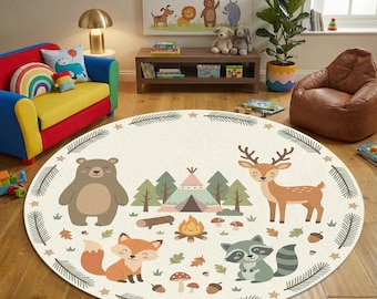 Könnte beinhalten: Runder, cremefarbener Teppich mit Waldmotiv. Er zeigt einen Bären, Fuchs, Hirsch, Waschbär, Tipi, Lagerfeuer, Bäume und Blätter. Der Rand hat ein Muster aus Tannennadeln und Sternen. Ideal für ein Kinderzimmer.