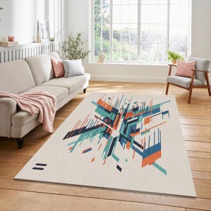 May include: A rectangular rug with a geometric design in teal, navy, and orange on a cream background. The rug features a modern abstract pattern with lines and shapes. Two short, parallel navy lines are on the lower left corner.