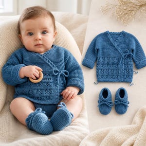 May include: A blue knitted baby outfit set, including a wrap-style cardigan, matching booties, and a bodysuit. The cardigan and booties have tie closures. The baby is holding a wooden teething ring. The set is displayed on a cream-colored surface.