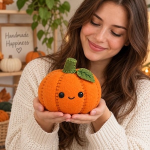 Può includere: Un peluche a forma di zucca in feltro arancione con cuciture marrone scuro a vista, due piccoli occhi a perla neri, un semplice sorriso ricamato e un picciolo in feltro verde con una singola foglia verde attaccata sulla parte superiore.