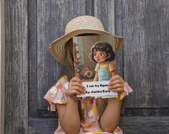 May include: A children's book titled "I can try Again" by Justina Early. The book cover features an illustration of a young girl in a yellow shirt and blue dungarees. The girl is holding the book in front of her face, wearing a straw hat and a pink dress.