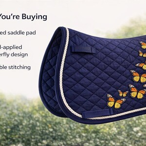 May include: A navy blue quilted saddle pad with a white trim and hand-applied butterfly design. The butterflies are orange and yellow. The saddle pad has durable stitching.