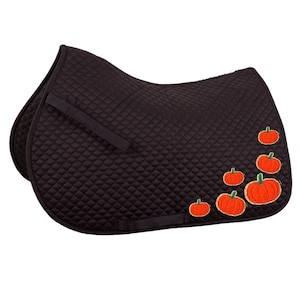 May include: A black quilted saddle pad with orange embroidered pumpkins of varying sizes. The pad has a diamond pattern and black straps for securing it to the horse. A festive equestrian accessory.
