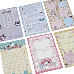 Op de afbeelding: Een verzameling kleurrijke briefpapierbladen met verschillende stripfiguren. De bladen bevatten lijnen en rasterpatronen, met decoratieve elementen zoals harten, sterren en karakterillustraties. Het kleurenpalet omvat pasteltinten en heldere tinten.