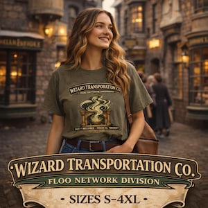 May include: Olive green t-shirt with the text "WIZARD TRANSPORTATION CO." and a graphic of a fireplace with smoke. The shirt also has the text "FAST - RELIABLE - MAGICAL TRANSIT SINCE 1639". The shirt is paired with blue jeans and a brown leather bag.