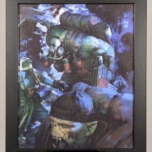 Puede incluir: Obra de arte enmarcada que representa una escena de batalla con figuras de piel verde con armaduras y cascos. La obra presenta un estilo oscuro y detallado con un enfoque en la acción y el conflicto. El marco es negro.