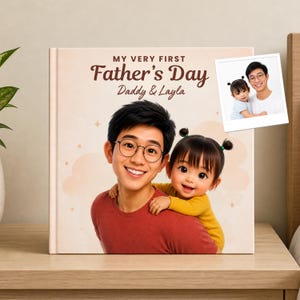 May include: A personalized Father's Day book titled "My Very First Father's Day" featuring a smiling father and child illustration. The cover includes the names "Daddy & Layla" and a small photo of the pair. The book is on a wooden surface.