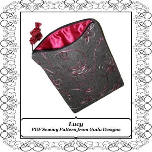 May include: A gray felt zippered pouch with a pink satin lining and a pink tassel. The pouch has a floral design embroidered on the front. The text "Lucy PDF Sewing Pattern from Gaila Designs" is printed below the image.