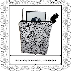 May include: A black and white floral print fabric pouch with a black tassel. The pouch is designed to hold an e-reader, such as a Nook. The text "My NOOK" and "nook" are visible on the e-reader.