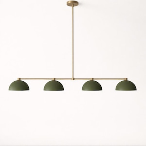 May include: A modern, four-light pendant light fixture. The fixture features four olive green dome-shaped shades suspended from a horizontal brass-colored bar. A vertical brass-colored rod connects the bar to a ceiling mount.