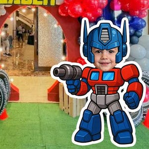 Puede incluir: Una entrada de fiesta festiva decorada con globos rojos, blancos y azules, y una pancarta que dice "Jaden". Una imagen de dibujos animados de Optimus Prime está en primer plano. La entrada está enmarcada por neumáticos.