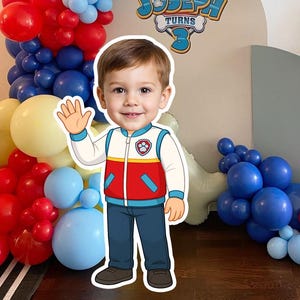 Puede incluir: Escena de fiesta de cumpleaños con un arco de globos en rojo, azul y amarillo. Un recorte de un niño con un atuendo temático de la Patrulla Canina saluda. El letrero dice "Joseph Turns 3".