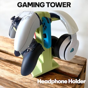 May include: A light green gaming tower with the text "GAMING TOWER" and "Headphone Holder". The tower holds a white headset, a blue Nintendo Switch controller, and multiple black and white game controllers.