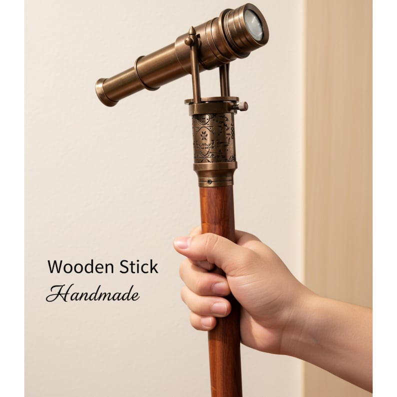 May include: A vintage-style brass telescope with a wooden handle. The telescope is held in a hand and features intricate detailing. The text "Wooden Stick Handmade" is visible on the image. A decorative item.