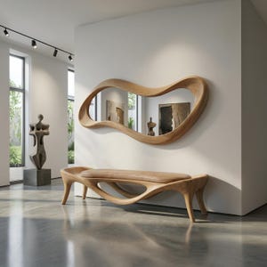 May include: A light brown wooden bench with a smooth, curved, organic frame and a tan upholstered seat, positioned below a large, matching light brown wooden wall mirror with an irregular, flowing, wave-like frame mounted on a white wall.