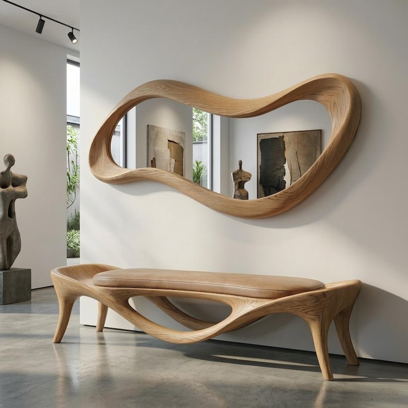 May include: A large, horizontal, wavy-shaped wall mirror with a light-toned wood frame, mounted above a matching wooden bench. The bench features a smooth, light brown upholstered seat and a curved, organic wooden base with four legs.