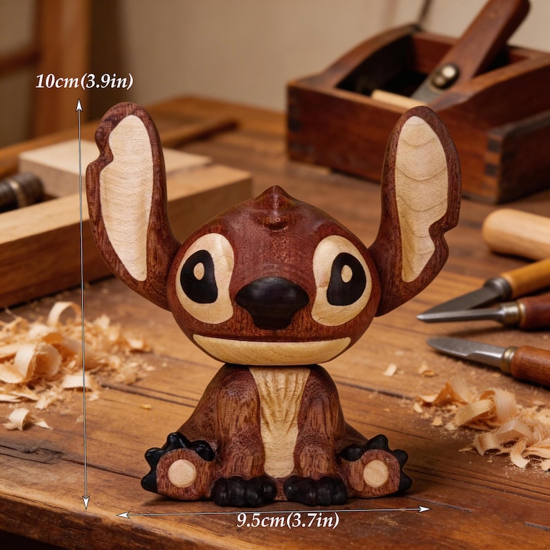 May include: A handcrafted wooden figurine of a cartoon character, featuring a dark brown body with lighter wood accents on the ears and belly. The figurine is approximately 3.9 inches (10cm) tall and 3.7 inches (9.5cm) wide. The character has large black eyes and a black nose.