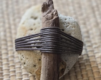 Roca costera envuelta con madera flotante