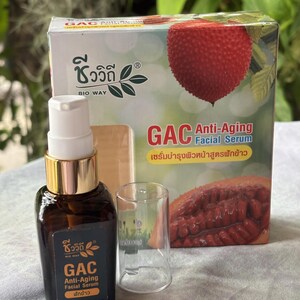 K&ouml;nnte beinhalten: Eine braune Glaspumpeflasche mit GAC Anti-Aging Gesichtsserum, schwarzem Etikett und wei&szlig;er Schrift, dazu eine transparente Kunststoffkappe und eine rechteckige Pappschachtel mit einer roten Gac-Frucht und dem Text GAC Anti-Aging Facial Serum.