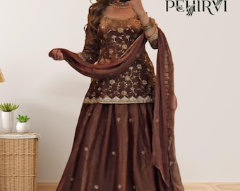 Puede incluir: Un vestido formal marrón bordado con una bufanda a juego. El vestido presenta detalles dorados y bordados florales. La marca "PEHIRVI" es visible en la esquina superior derecha. El atuendo es adecuado para ocasiones especiales.