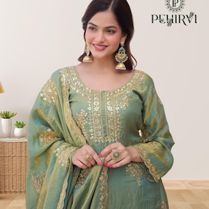 May include: A seafoam green ensemble featuring intricate gold embroidery. The outfit includes a long-sleeved tunic and a matching scarf. The design is embellished with gold accents and the brand name "PEHIRVI" is visible in the upper right corner.