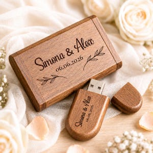 Może przedstawiać: Prostokątne drewniane etui na pamięć USB oraz pasująca drewniana pamięć USB z zatyczką. Oba przedmioty są wygrawerowane imionami Simona & Alex, datą 06.06.2026 oraz małymi ilustracjami liści. Drewno posiada naturalne usłojenie.